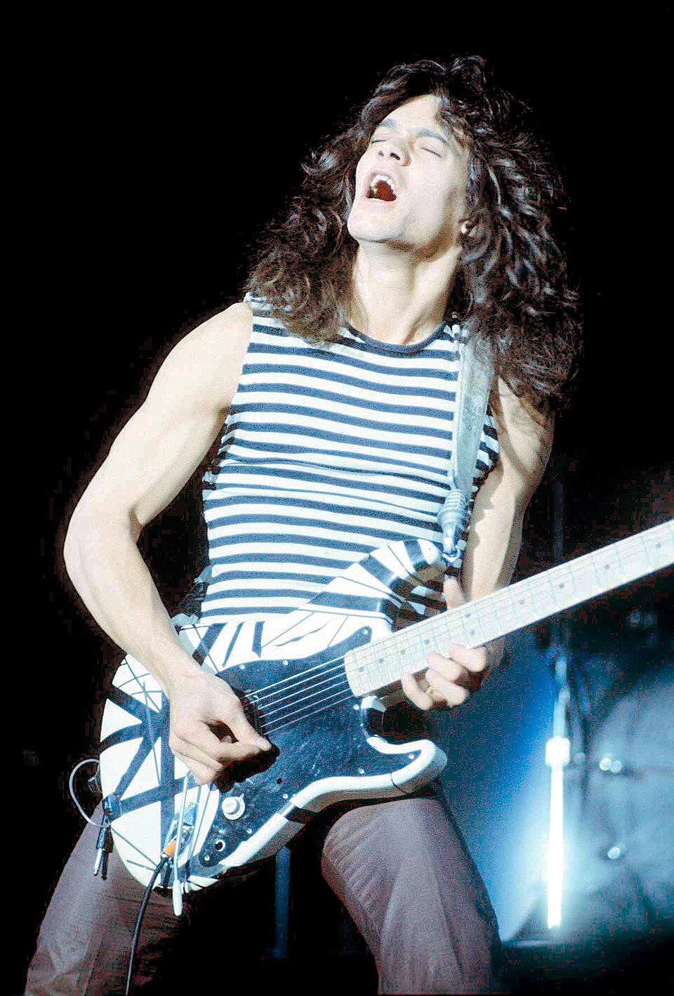 Eddie Van Halen playing guitar on stage in 1978.