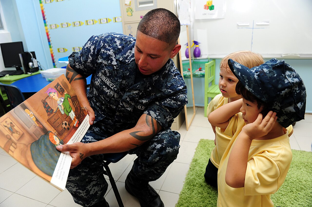 A US Navy sailor reads to a group of pre-school children in a classroom at an international school in Singapore, 2011.