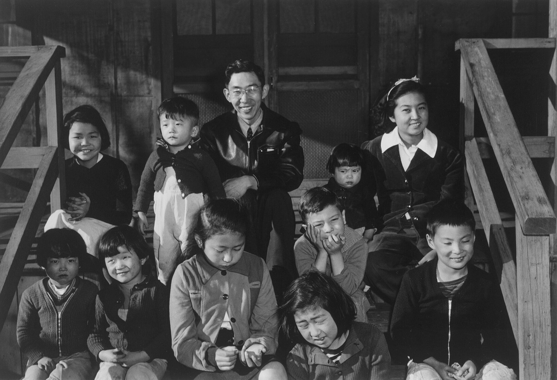 Harry Matsumoto, superintendent of the Children's Village at Manzanar, standing with a group of orphan children in 1943.