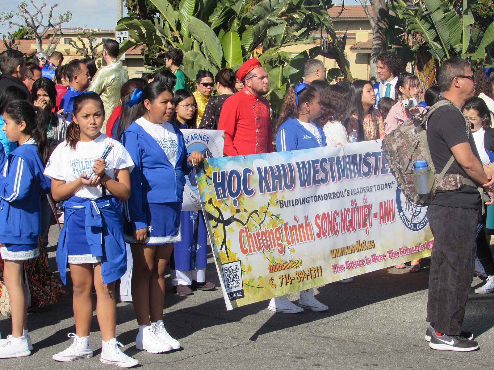 Students and staff of a Vietnamese-English bilingual programme march behind a banner at a Lunar New Year parade.