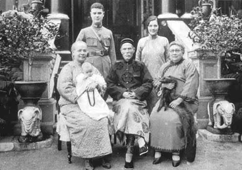 A large family group of three generations posed on steps, Hong Kong, about 1930.