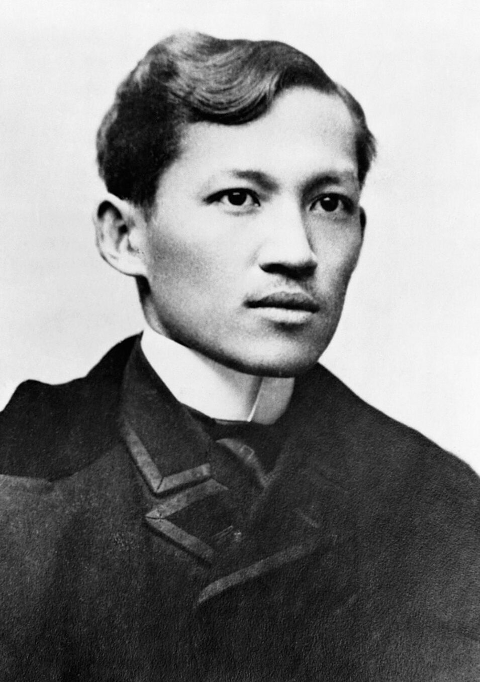 Full-length studio photograph of Jose Rizal in a dark overcoat, 1890s.